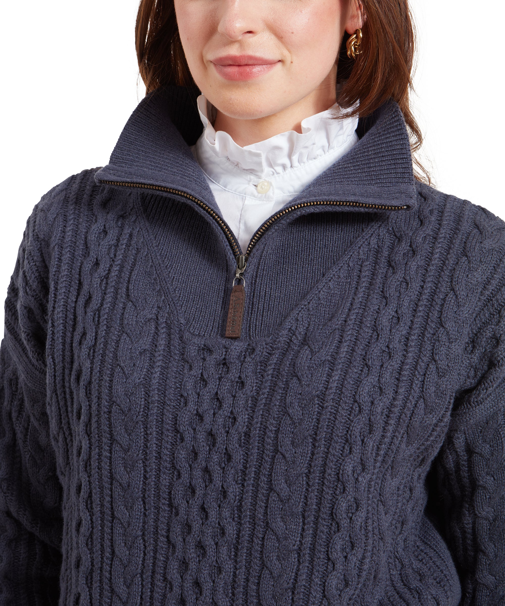 A close-up of the quarter-zip collar of the Schöffel Settle 1/4 Zip for Women in Navy, showing the textured knit details and the quality of the zipper, as well as the intricate ruffled collar of the white shirt worn underneath.