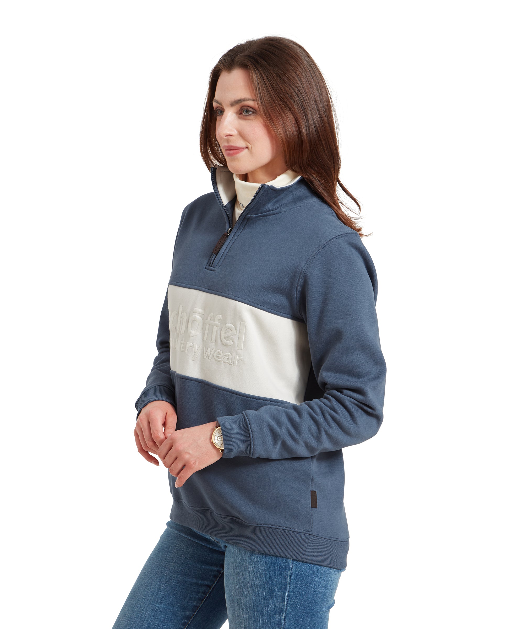 A side profile of the woman wearing the Schöffel St Agnus Sweatshirt for Women in Navy. The focus is on the left side of her body, highlighting the fit of the sweatshirt and her relaxed posture.