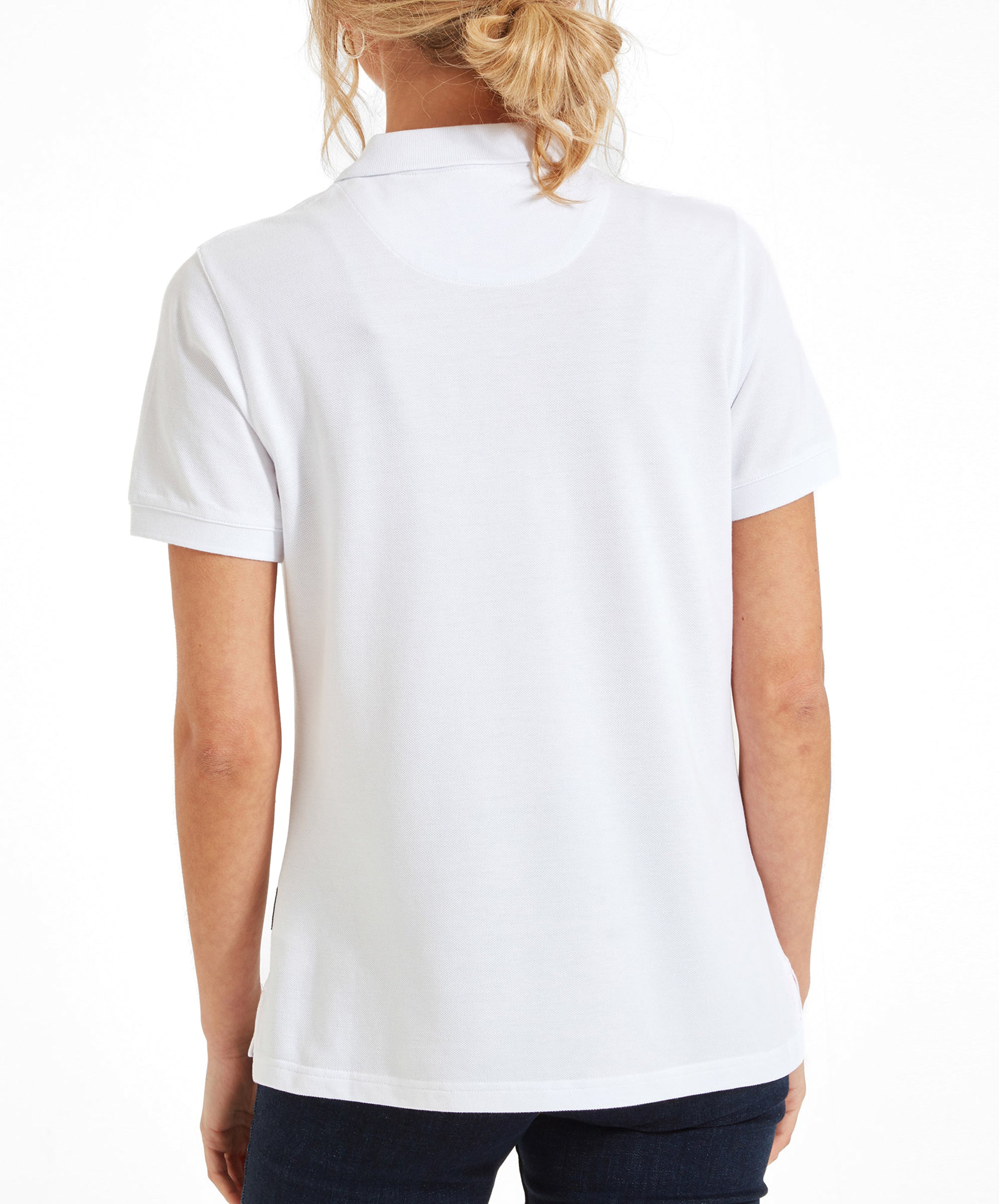 Back view of the Schöffel Women's St Ives Polo Shirt for Women in White. The models hair in a loose bun.