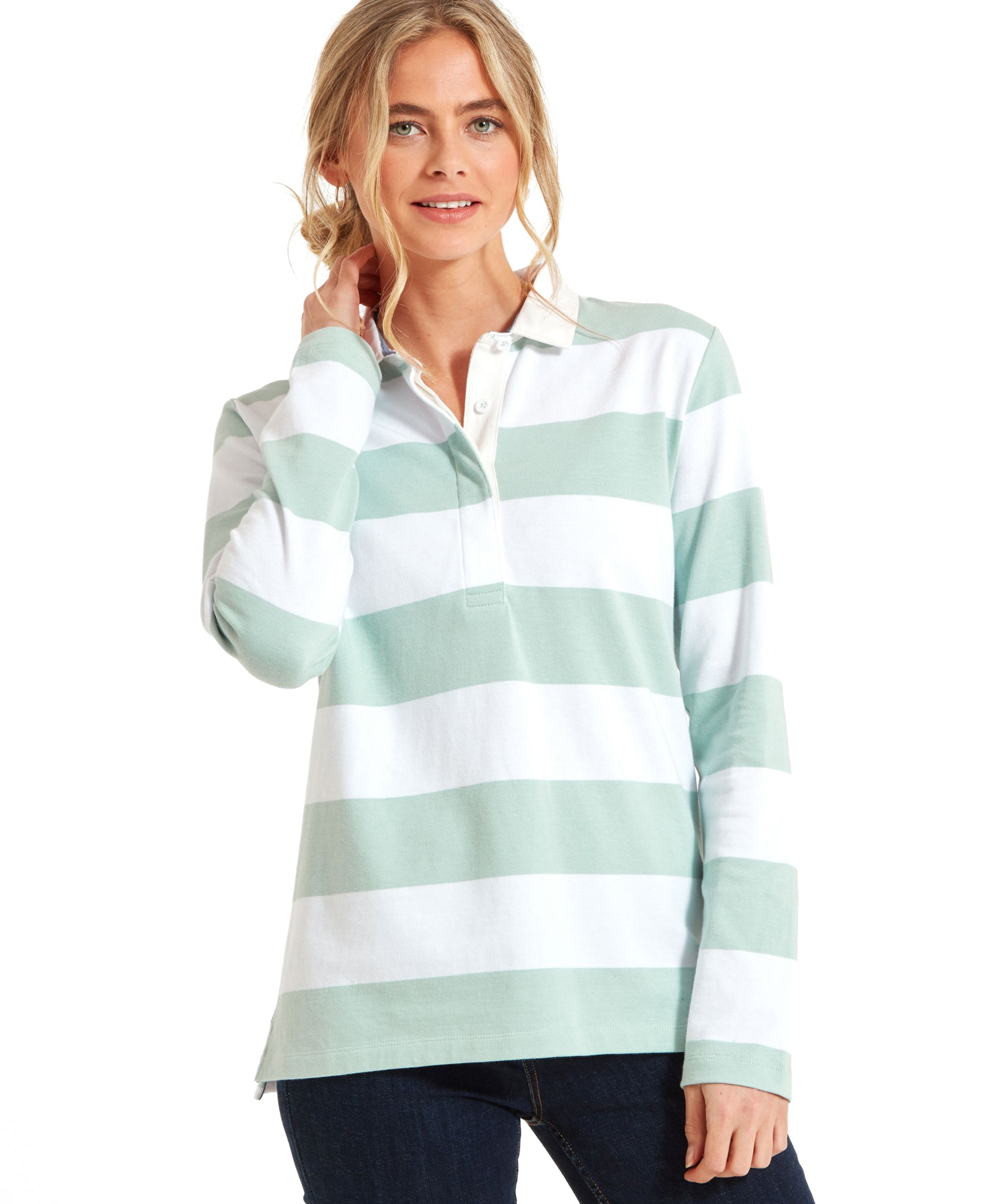 A woman wearing a Schöffel St Mawgan Rugby Shirt for Women in Green. The shirt features wide horizontal stripes in green and white, a white collar, and a button placket. The model is casually posing with one hand touching her neck.