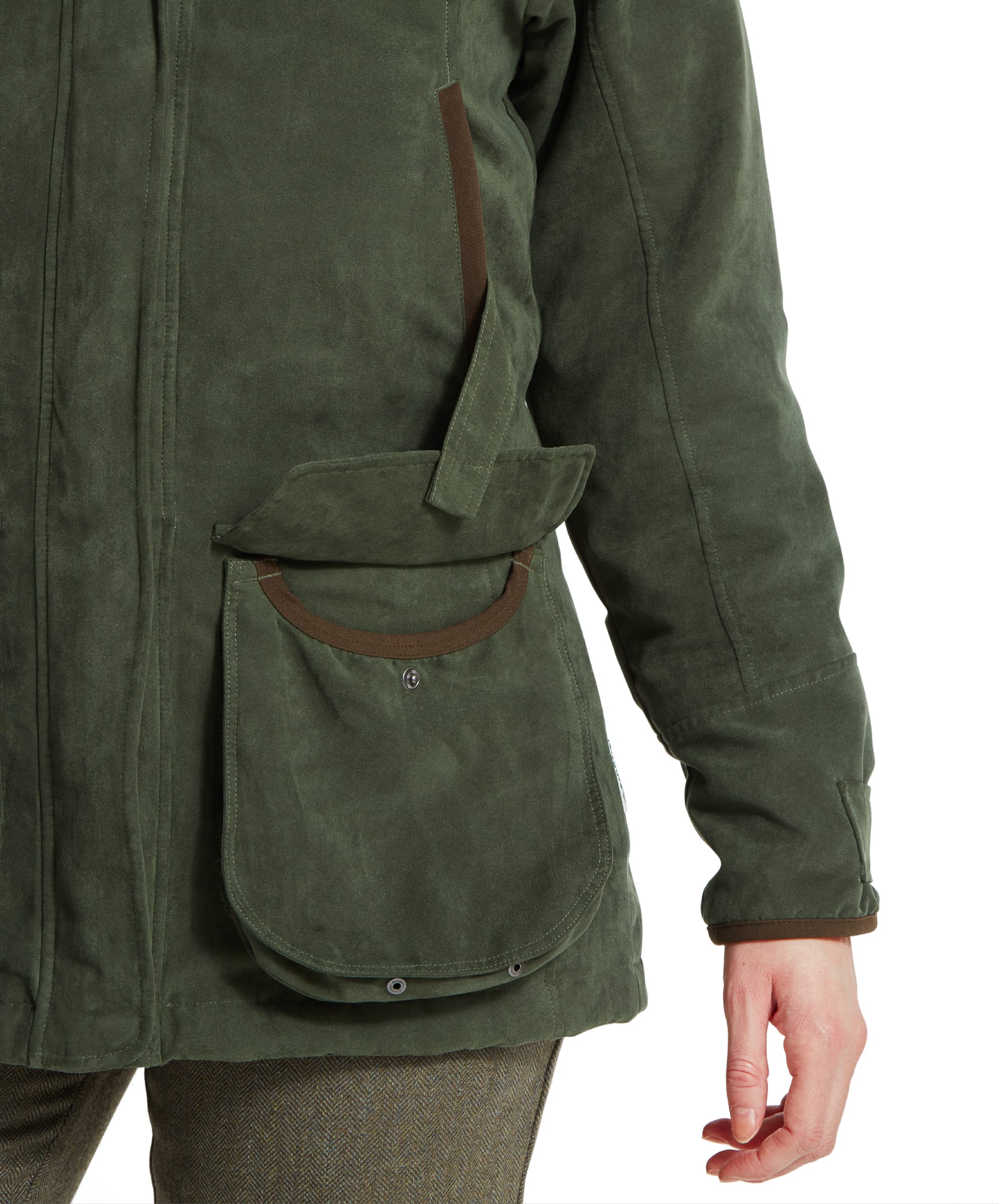 A close-up view of the right pocket and sleeve, with the woman’s hand resting near the pocket. The pocket has a buttoned flap, brown trim, and is slightly open, revealing the pocket lining. The texture of the Schöffel Teal Shooting Coat for Women in Green and the sleeve cuff detail are clearly visible.