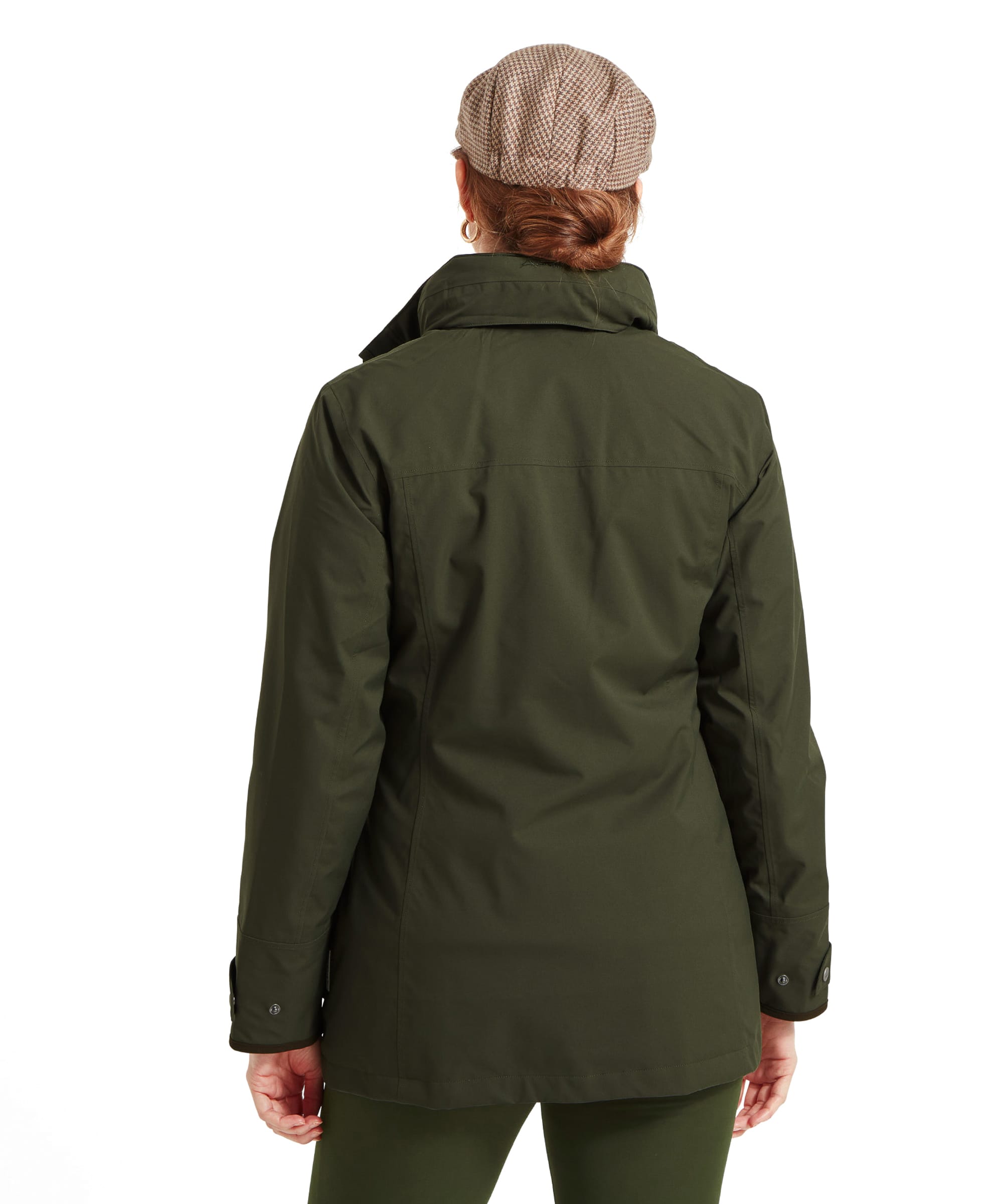 This image displays the back of the Schöffel Teal Ultralight Coat for Women in Greenworn by the woman. The jacket falls just below the hips and has a clean, minimalist design with no visible seams or patterns. The woman’s hair is tied back in a low bun, and the collar of the jacket is turned up slightly.