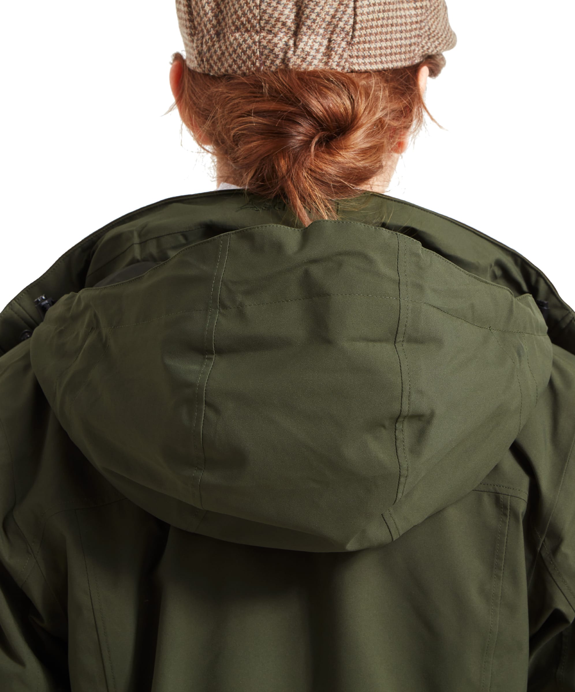 The woman is seen from the back again, this time with the Schöffel Teal Ultralight Coat for Women in Green's hood pulled out. The hood is made of the same material as the jacket, blending seamlessly in color and texture. The hood appears adjustable and fits neatly around the collar when not in use.