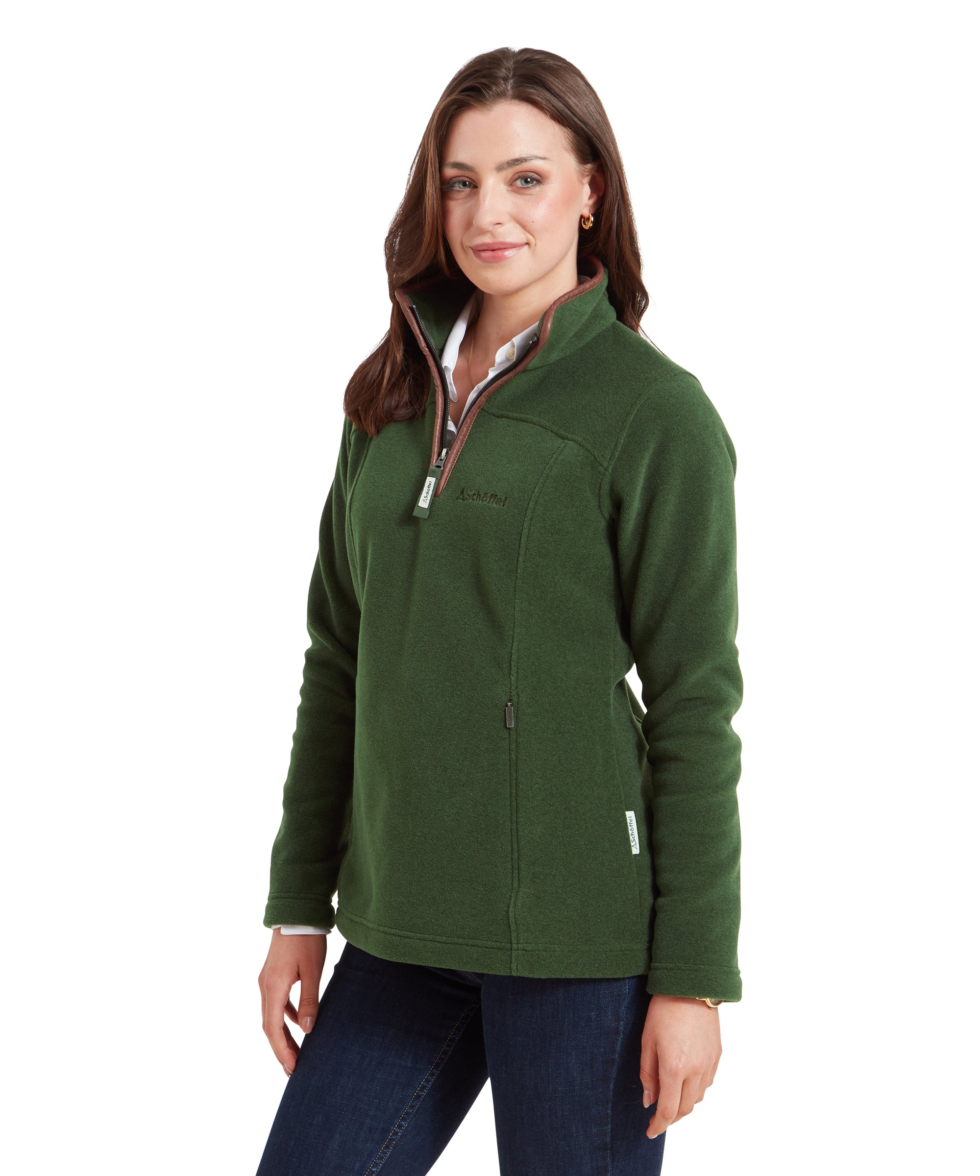 The same woman is shown in a closer, three-quarter view, providing a clearer look at the Schöffel Tilton 1/4 Zip Fleece for Women in Light Green’s fit and details. The high collar is partially unzipped, revealing the shirt underneath. Her hair is styled loosely, and she smiles softly with a relaxed posture.