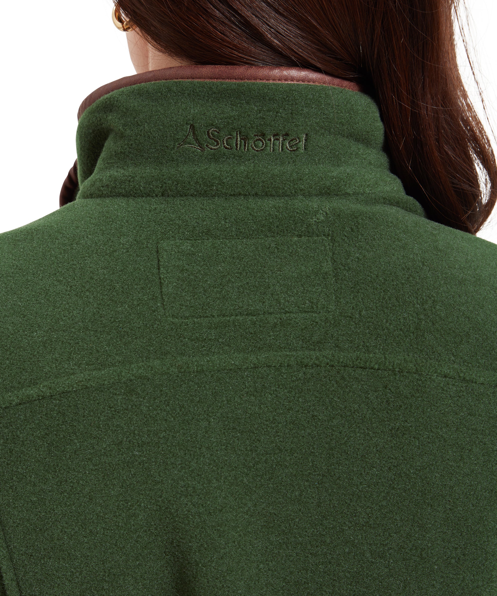 This image zooms in on the back of the Schöffel Tilton 1/4 Zip Fleece for Women in Light Green, focusing on the collar and upper back area. The collar is trimmed with brown fabric, and the brand’s logo is subtly embroidered in green, blending with the fleece’s color. The image highlights the attention to detail and quality craftsmanship.