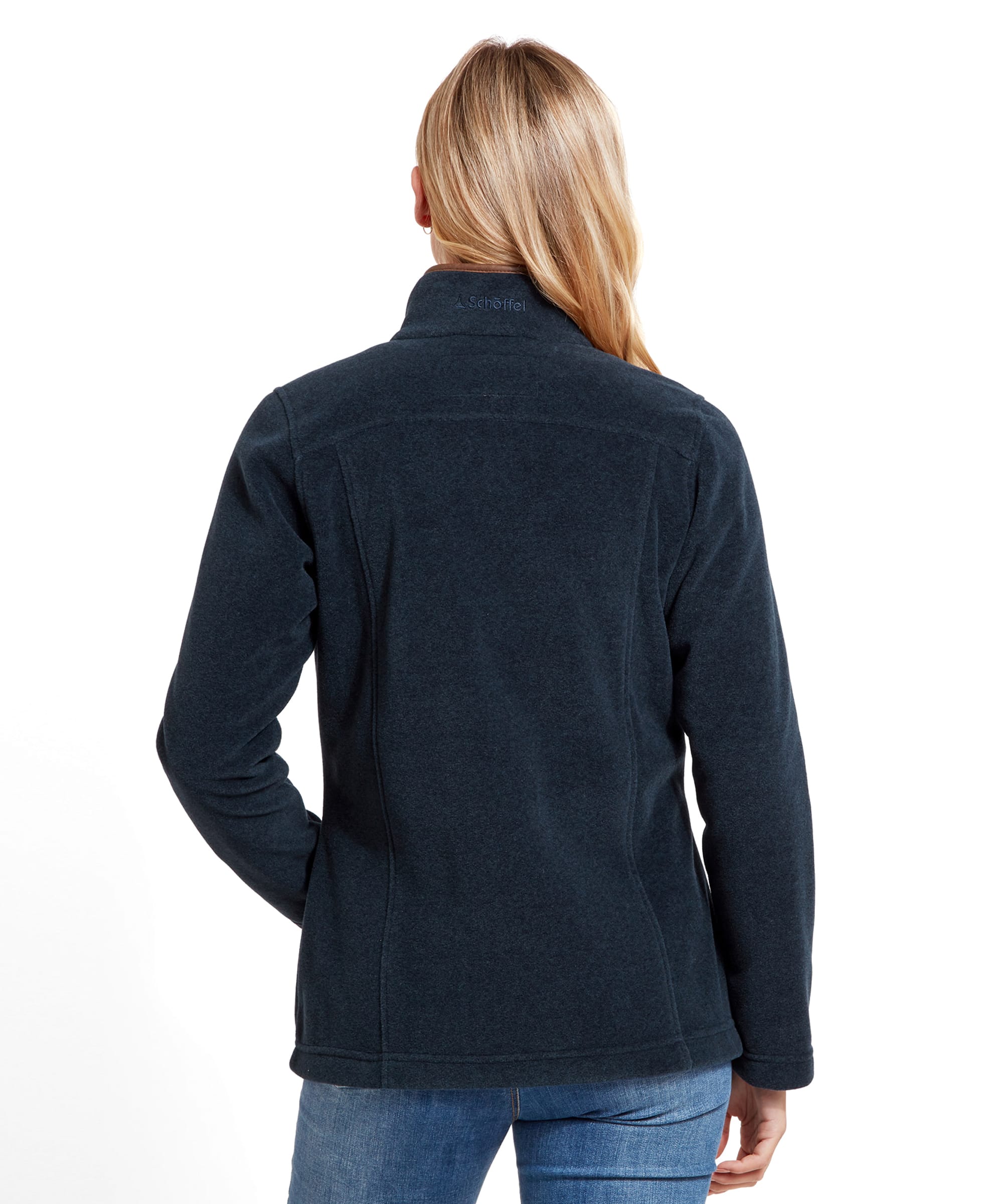 The woman is shown from the back, highlighting the simple and clean design of the Schöffel Tilton 1/4 Zip Fleece for Women in Blue. The fleece fits snugly around the shoulders and waist, with subtle seam details that provide a tailored look. Her blonde hair is straight and drapes down her back, emphasizing the high collar of the fleece.