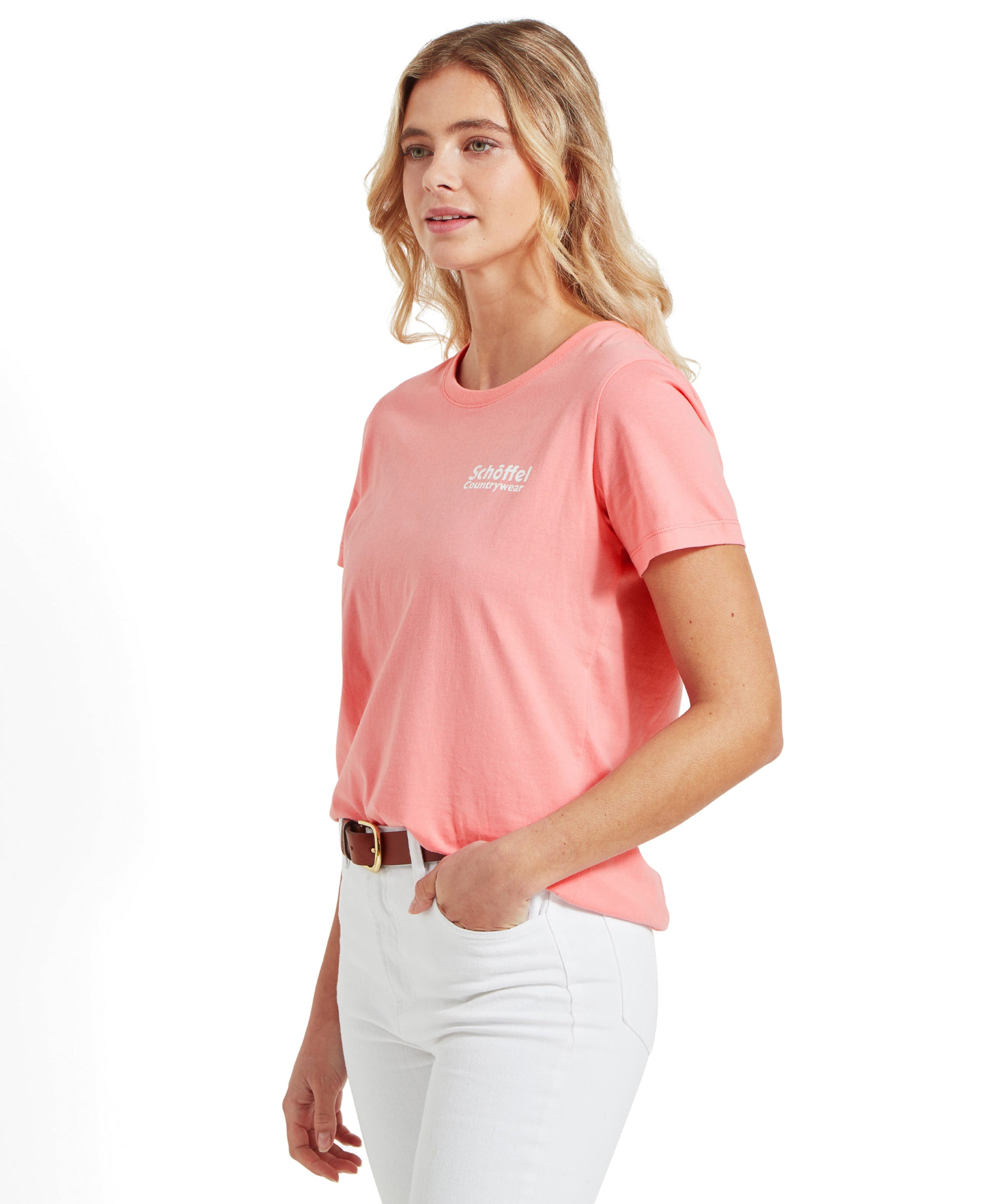 Side view of the model in the Schöffel Torre T Shirt for Women in Pink and white jeans, looking to her left.