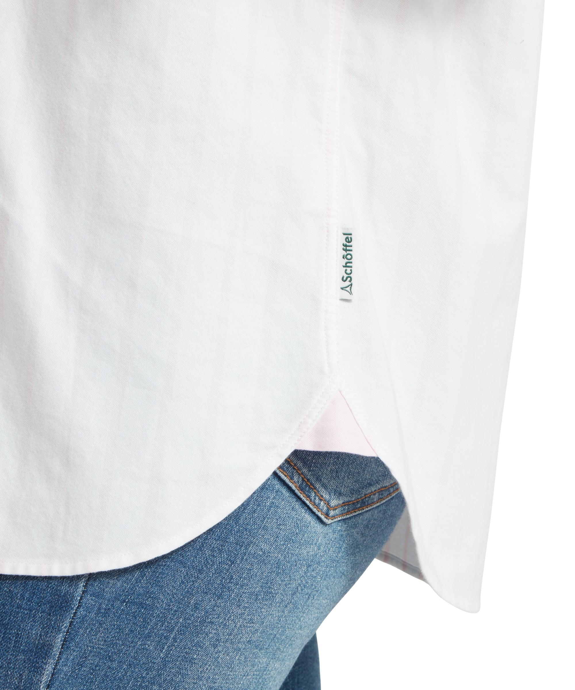 Close-up of a female model wearing a white and pink striped Schöffel shirt, paired with mid wash denim jeans. Image highlights the hem and "Schöffel" logo fabric side tag.