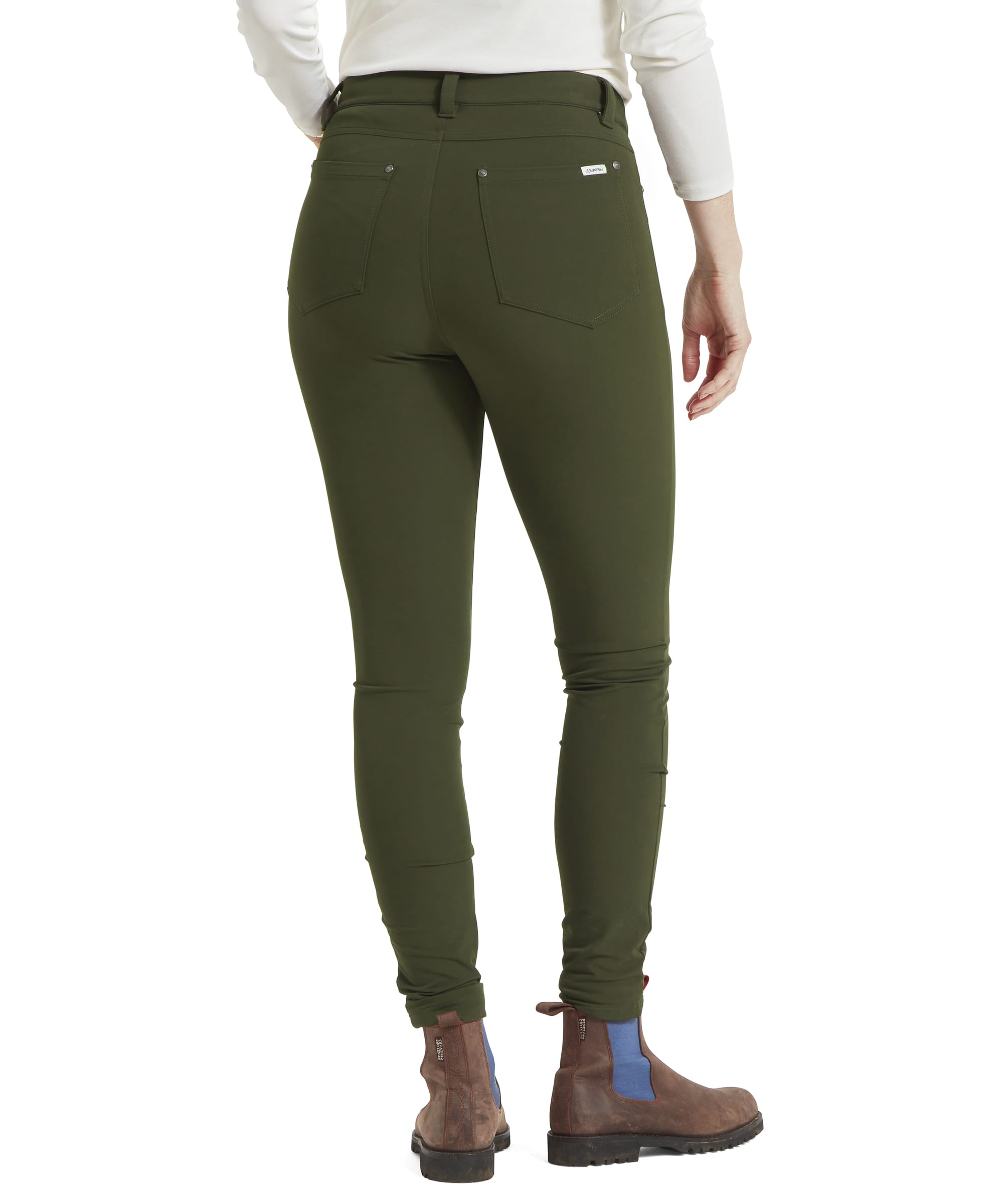 The image shows the back of the Schöffel Whitwell Water Repellent Trouser for Women in Green, highlighting the back pockets and seam detailing. The trousers have a sleek, streamlined fit, and the back pockets are neatly placed. The model’s boots are also visible from the back, showing the outfit's complete look.