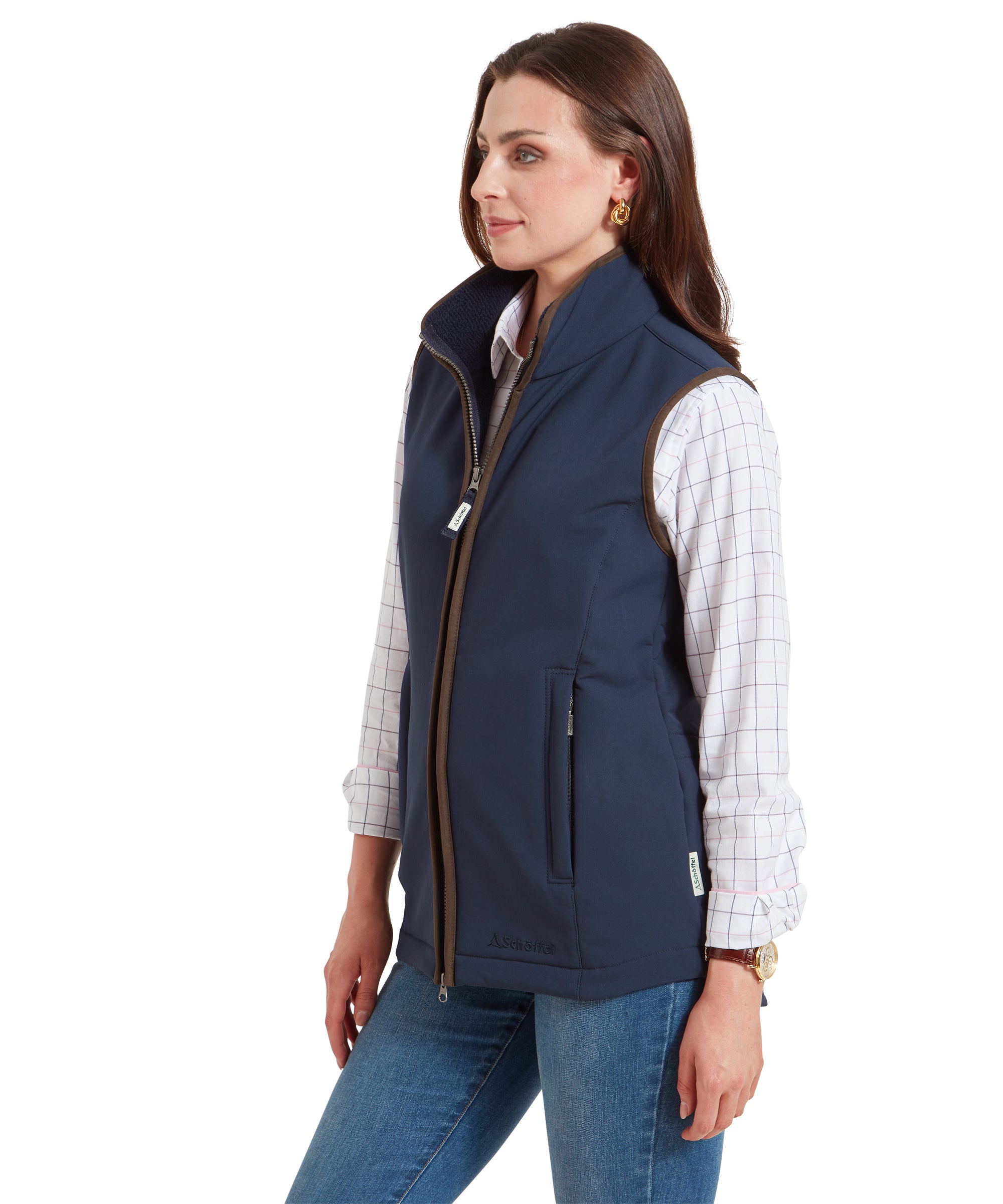 A side profile of the woman wearing the Schöffel Belton Gilet for Women in Navy, showing the high collar and the front zipper partially open, revealing the checkered shirt underneath.