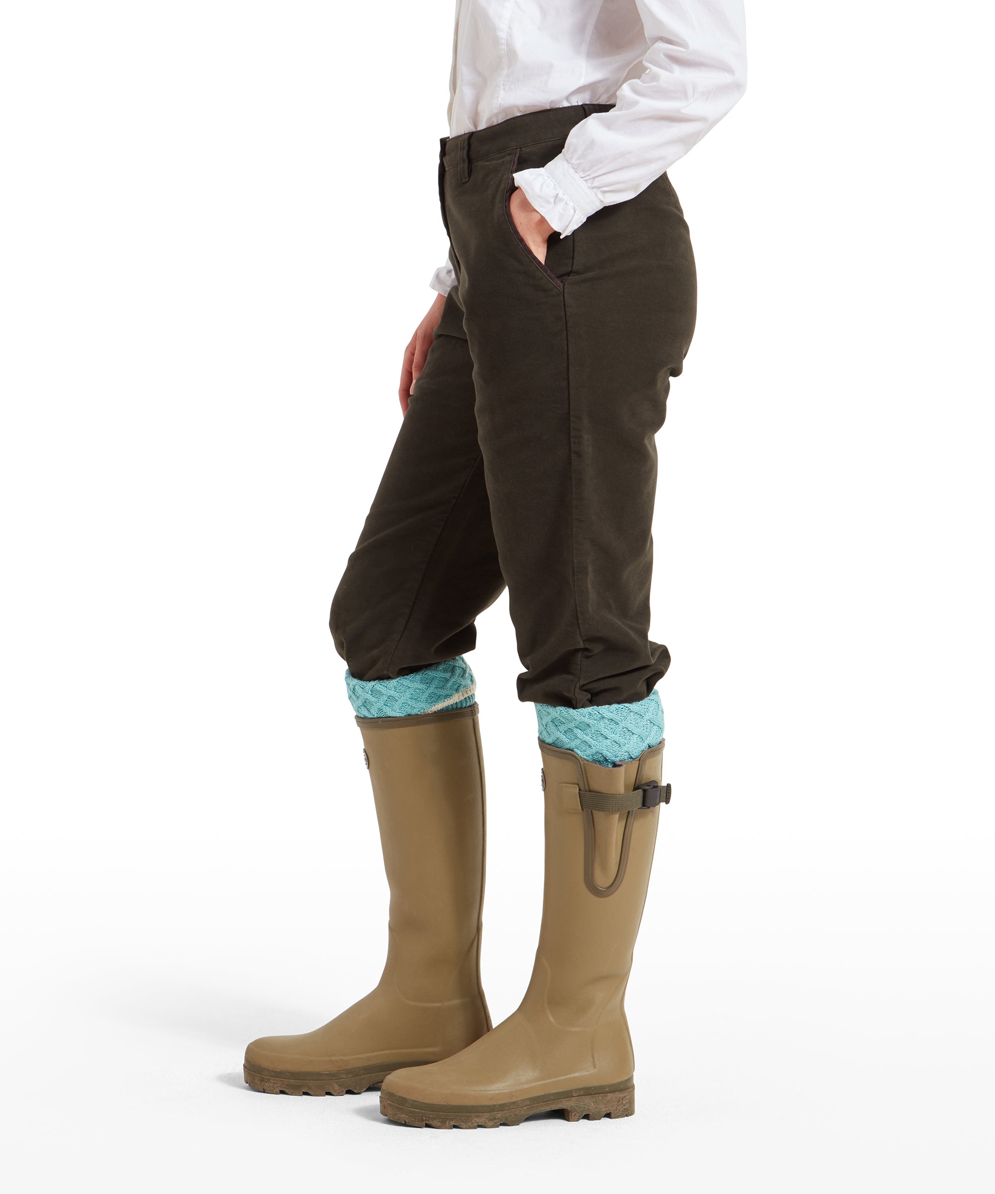 Side profile of a woman wearing Schöffel Moleskin Breeks for Womens in Green and beige wellington boots. The breeks are tucked into the boots with light blue knit socks visible. The woman’s left hand is casually placed in the pocket.