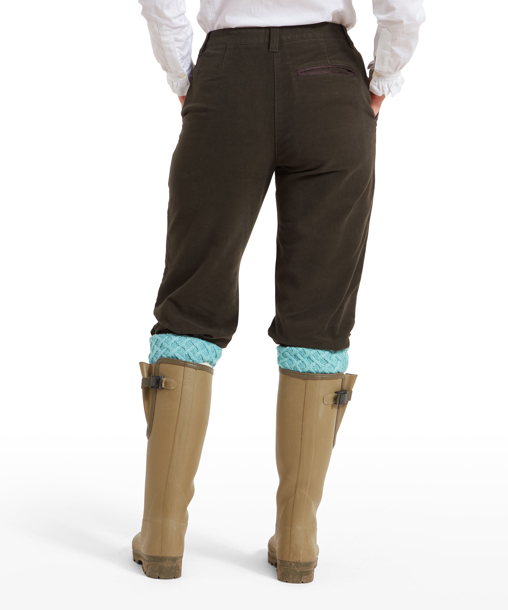 A rear view of a woman wearing Schöffel Moleskin Breeks for Womens in Green, showing the back pocket detail and the breeks tucked into beige wellington boots. Light blue knit socks are visible above the boots.